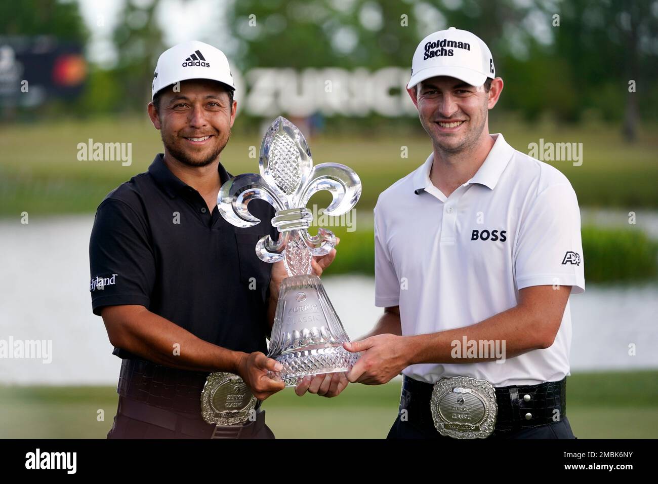 Xander Schauffele, left, and Patrick Cantlay, right, hold up the trophy