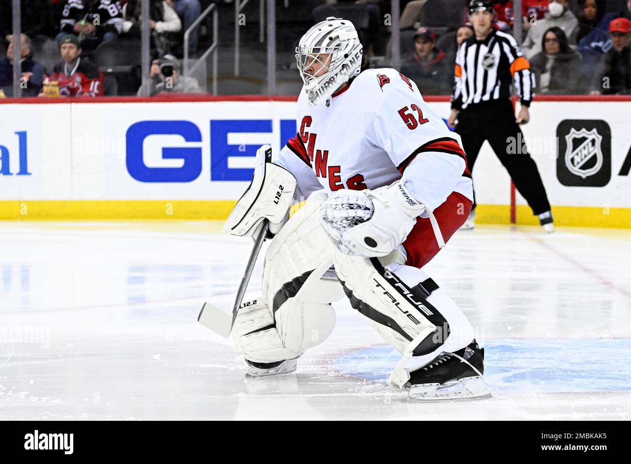 Carolina Hurricanes goaltender Pyotr Kochetkov (52) deflects the puck  during the first period of an NHL hockey game against the New Jersey Devils  Saturday, April 23, 2022, in Newark, N.J. (AP Photo/Bill