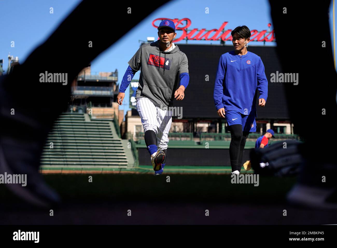 Chicago Cubs' Seiya Suzuki, left, is congratulated by first base coach Mike  Napoli after hitting a single against the San Francisco Giants during the  eighth inning of a baseball game in San