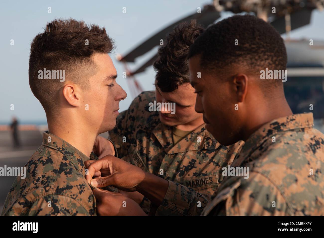 U.S. Marine Corps Cpl. Jonathan Robinson (right), a squad leader and Cpl. Jacob Obney, (center), a team leader, both with 1st Battalion, 8th Marine Regiment (1/8), 2d Marine Division, pin Lance Cpl. Cayden Kennon, a rifleman with 1/8,during Spanish FLOTEX-22 aboard the Juan Carlos I near Rota, Spain, June 16, 2022. This exercise features tactical level actions ashore, combined with joint training and planning, aimed at increasing overall bilateral interoperability between nations. Stock Photo