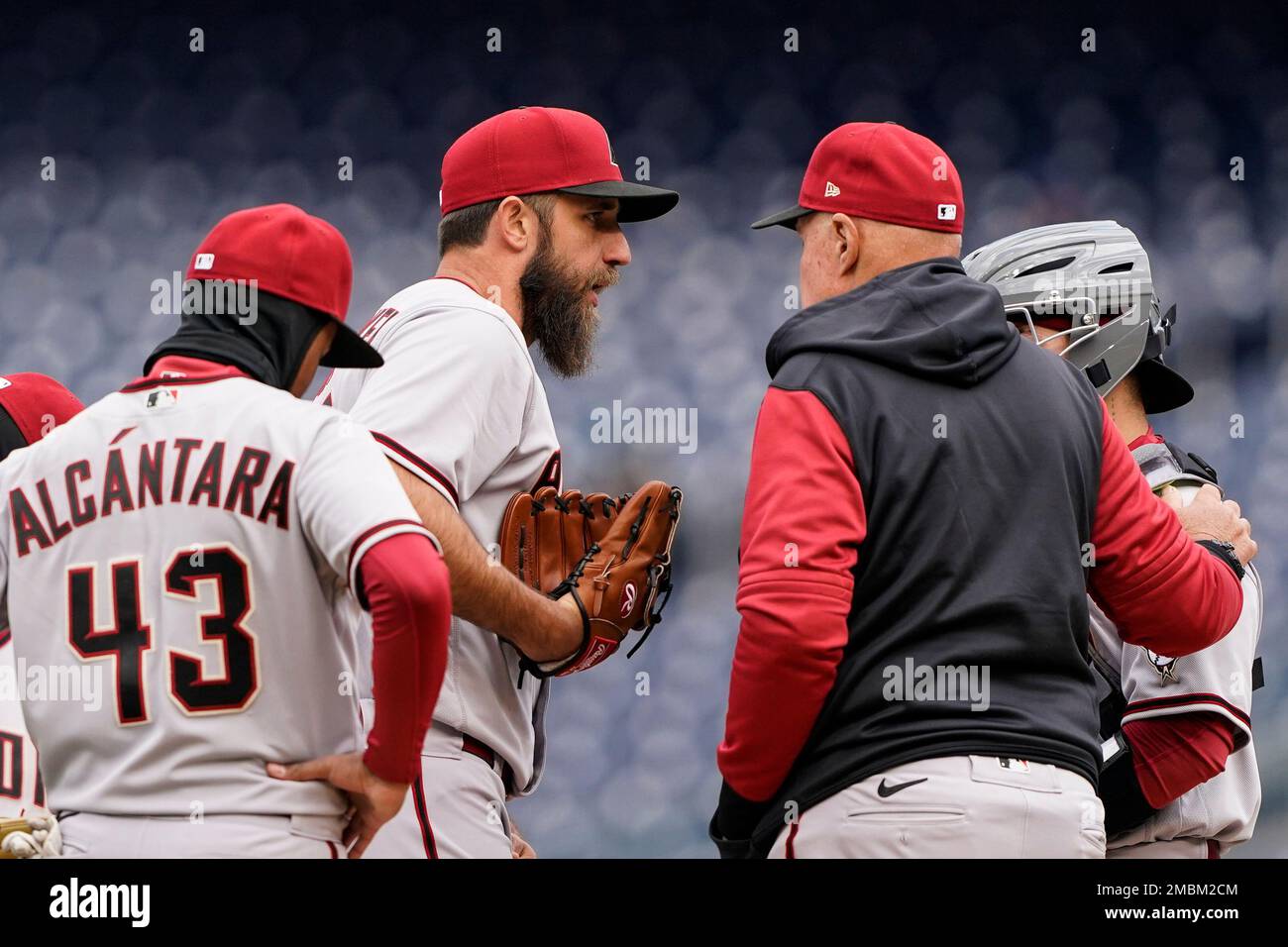 Arizona Diamondbacks starting pitcher Madison Bumgarner, second from left,  talks with Arizona Diamondbacks pitching coach Brent Strom, second from  right, on the mound during the first game of a baseball doubleheader at