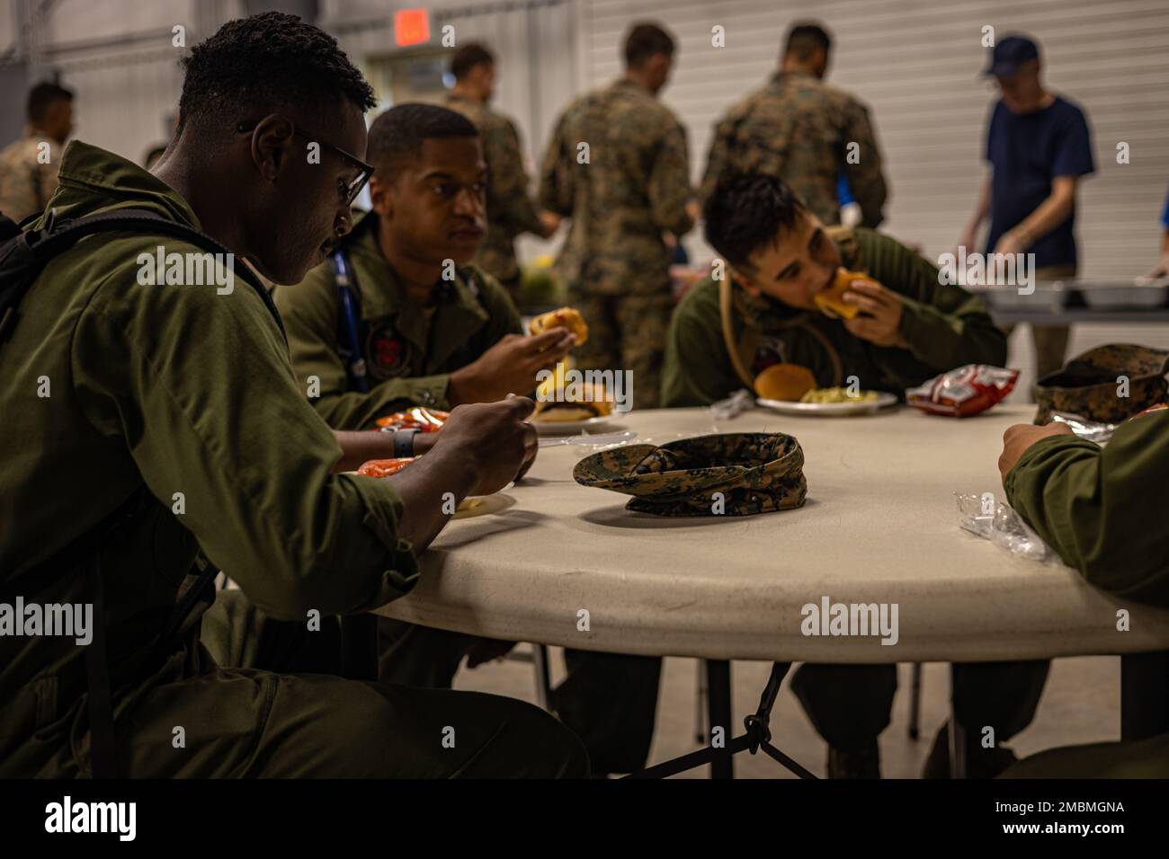 U.S. Marines with Marine Light Attack Helicopter Squadron (HMLA) 773 Detachment A, 4th Marine Aircraft Wing, eat hamburgers and hot dogs that are provided by Veterans of Foreign Wars (VFW) Post 1432 at Salina, Kansas on June 17, 2022. The VFW traces its roots back to 1899 when veterans of the Spanish-American War (1898) and the Philippine Insurrection (1899-1902) founded local organizations to secure rights and benefits for their service. Stock Photo