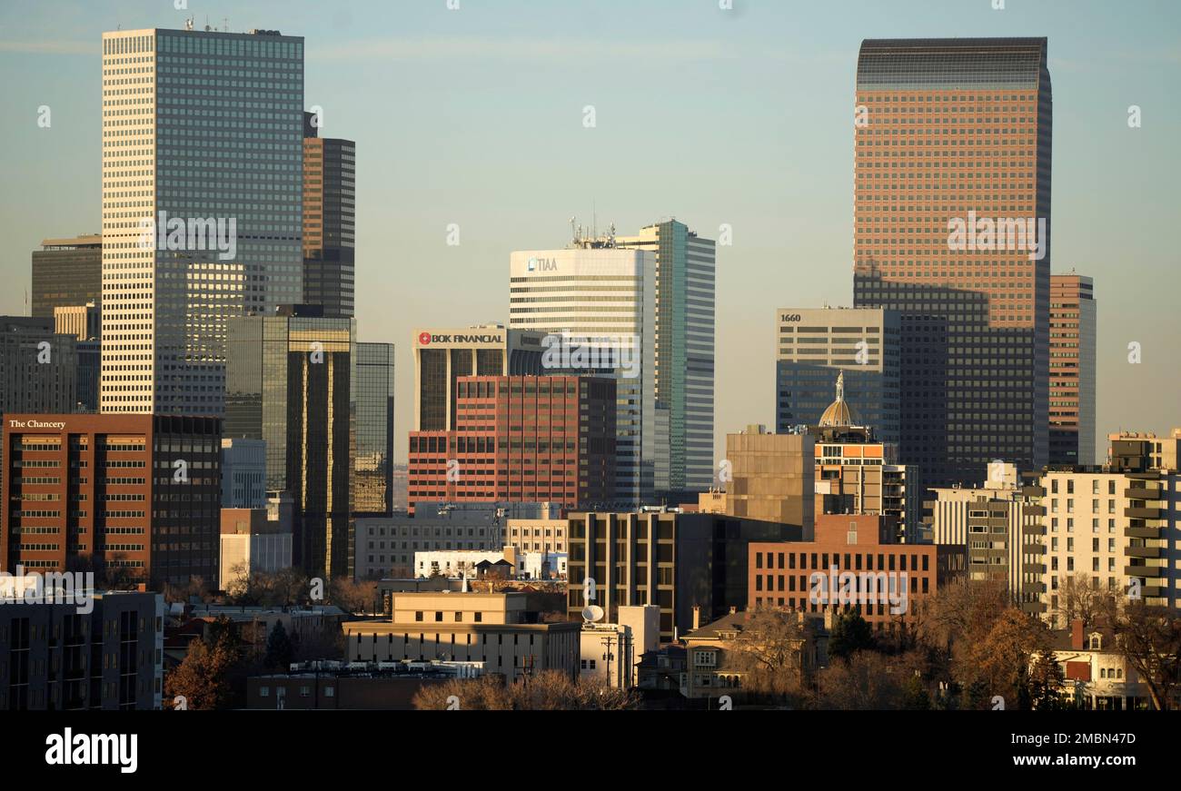 FILE - The Denver skyline is illuminated as the sun sets behind the Rocky  Mountains on Dec. 3, 2021. The U.S. Environmental Agency is proposing to  downgrade Colorado's biggest population center from