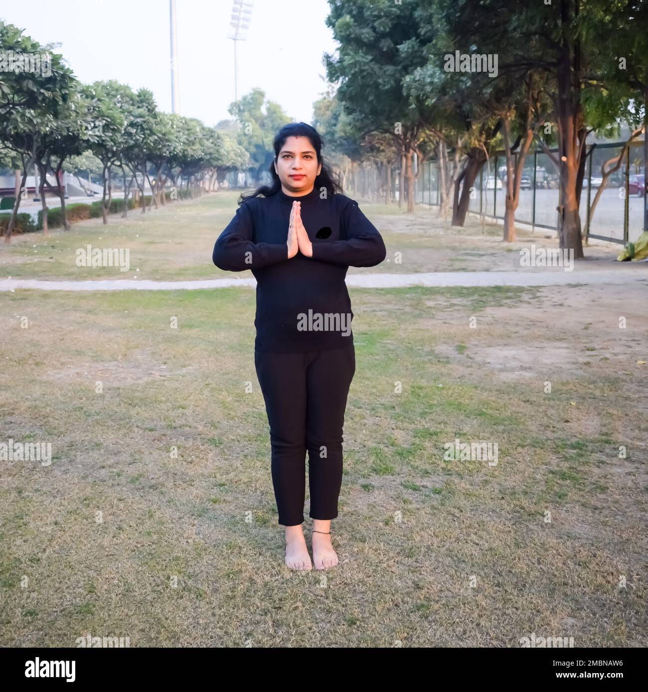 Young Indian woman practicing yoga outdoor in a park. Beautiful