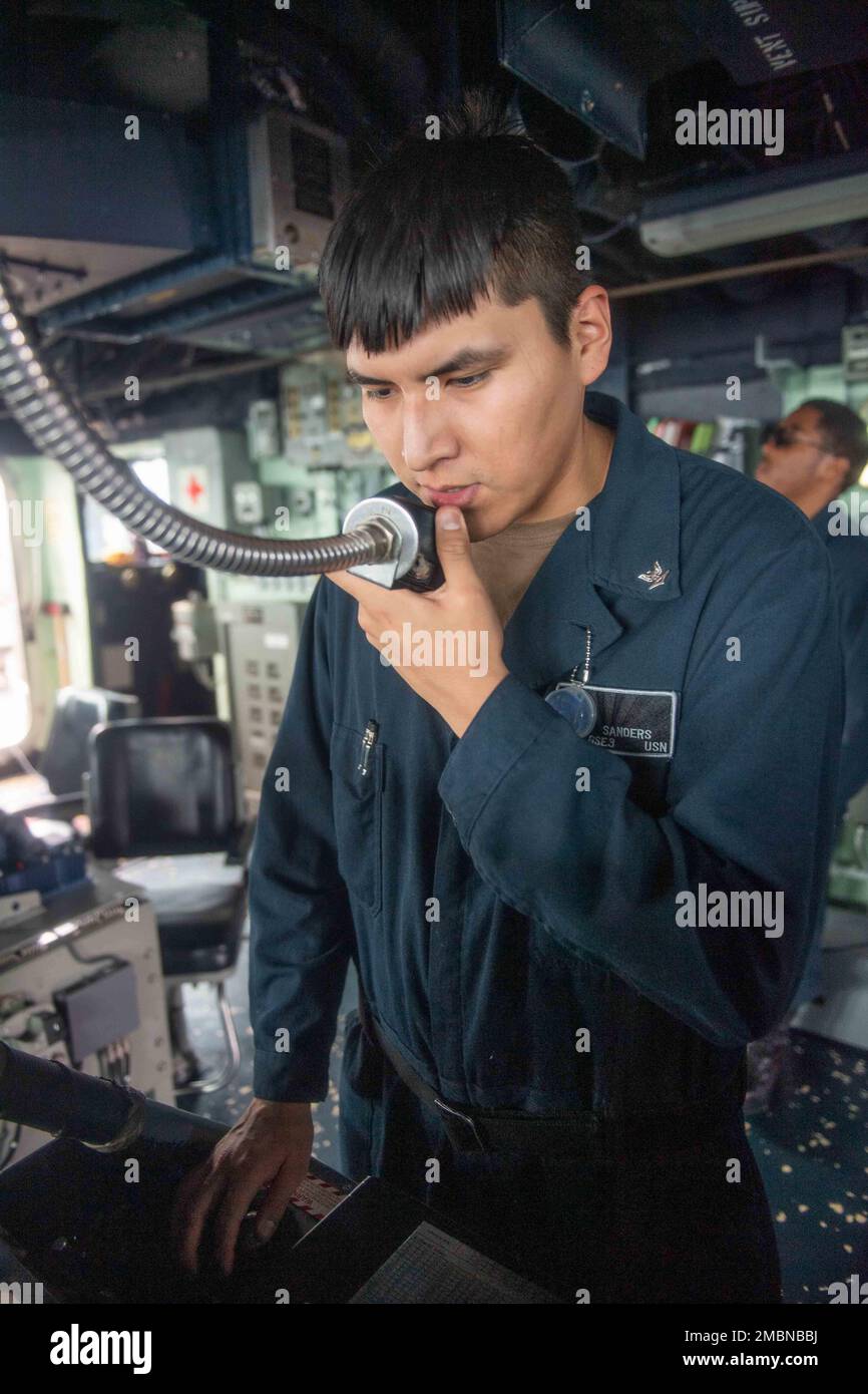 220617-N-VF045-1213 NORTH PACIFIC OCEAN (June 17, 2022)  Gas Turbine Systems (Electrical) 3rd Class Joshua Sanders, from Phoenix, confirms orders as a lee helmsman in the pilothouse aboard Arleigh Burke-class guided-missile destroyer USS Milius (DDG 69). Milius is assigned to Task Force 71/Destroyer Squadron (DESRON) 15, the Navy’s largest forward-deployed DESRON and the U.S. 7th fleet’s principal surface force. Stock Photo