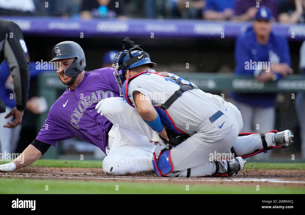Colorado Rockies' Kris Bryant, left, scores on a single by Ryan McMahon