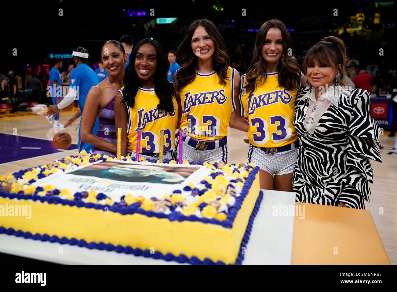 Laker girls and entertainer Paula Abdul, right, pose with a birthday cake  for NBA Hall of Famer Kareem Abdul-Jabbar during a celebration for his 75th  birthday at half-time of an NBA basketball