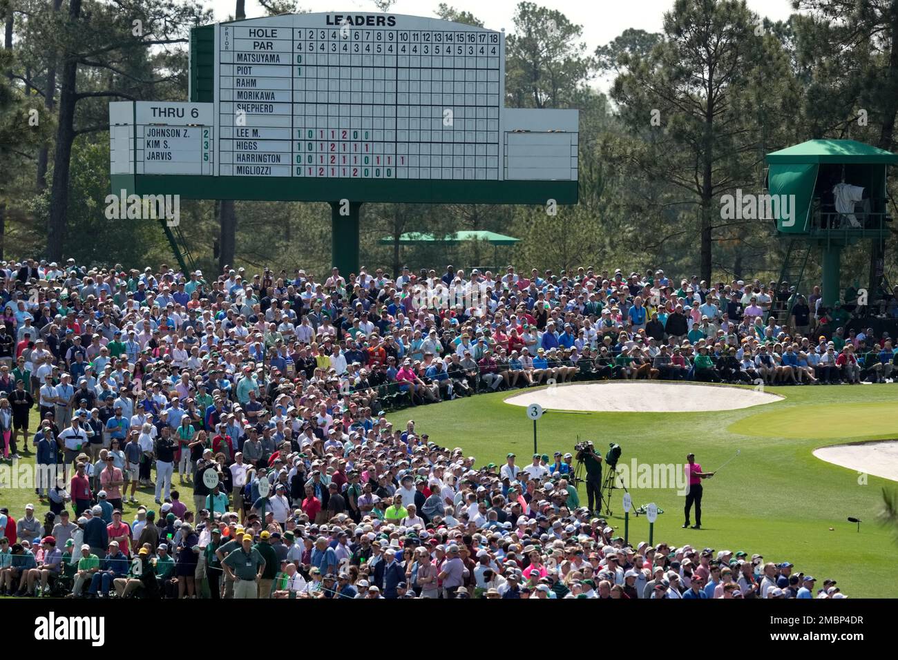Tiger Woods watches his tee shot on the third hole during the first