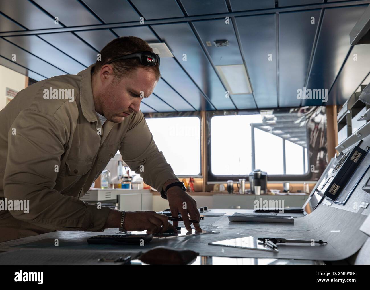 220618-N-TI693-1023    DJIBOUTI, Djibouti (June 18, 2022) Civilian mariner Colin Culpepper, ship's navigator, from Houston, plots the course of the Lewis B. Puller-class expeditionary sea base USS Hershel 'Woody' Williams (ESB 4) while entering the Port of Djibouti, June 18, 2022. Hershel “Woody” Williams is rotationally deployed to the U.S. Naval Forces Africa area of operations, employed by U.S. Sixth Fleet, to defend U.S., allied and partner interests. Stock Photo