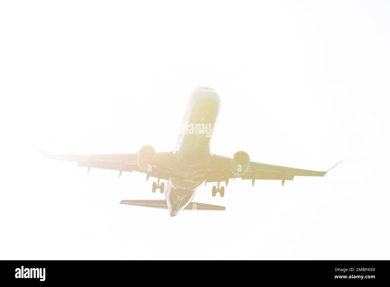 An airliner is silhouetted by the sun as it comes in for a landing at Seattle-Tacoma International Airport in SeaTac, Washington on Tuesday, January 1 Stock Photo