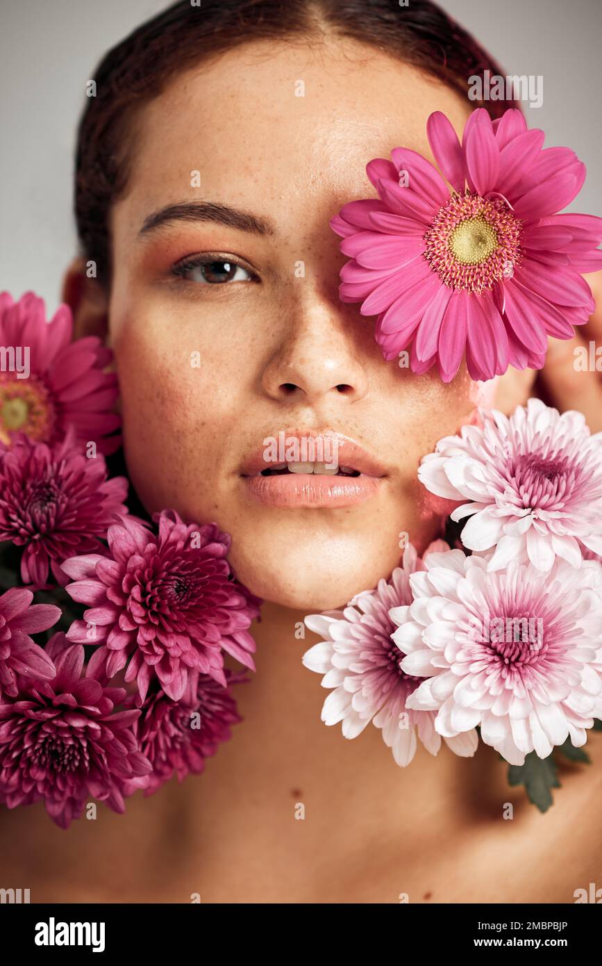 Woman, flowers and studio portrait for beauty, wellness and skincare