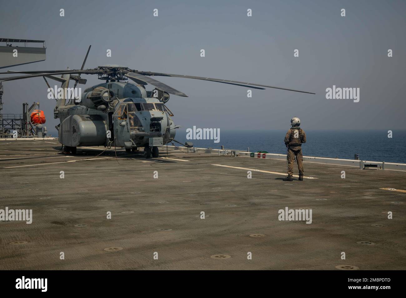 220618-A-EQ028-1184 ARABIAN GULF (June 18, 2022) Aviation Warfare Systems 3rd Class Kyle Gumz conducts preflight checks on an MH-53 Sea Dragon helicopter attached to the Blackhawks of Helicopter Mine Countermeasures (HM) Squadron 15, prior to flight operations aboard the expeditionary sea base USS Lewis B. Puller (ESB 3), during exercise Iron Defender in the Arabian Gulf, June 18. Iron Defender is an annual bilateral training event between U.S. Naval Forces Central Command and forces from the United Arab Emirates. The exercise focuses on maritime security operations, mine countermeasures, and Stock Photo