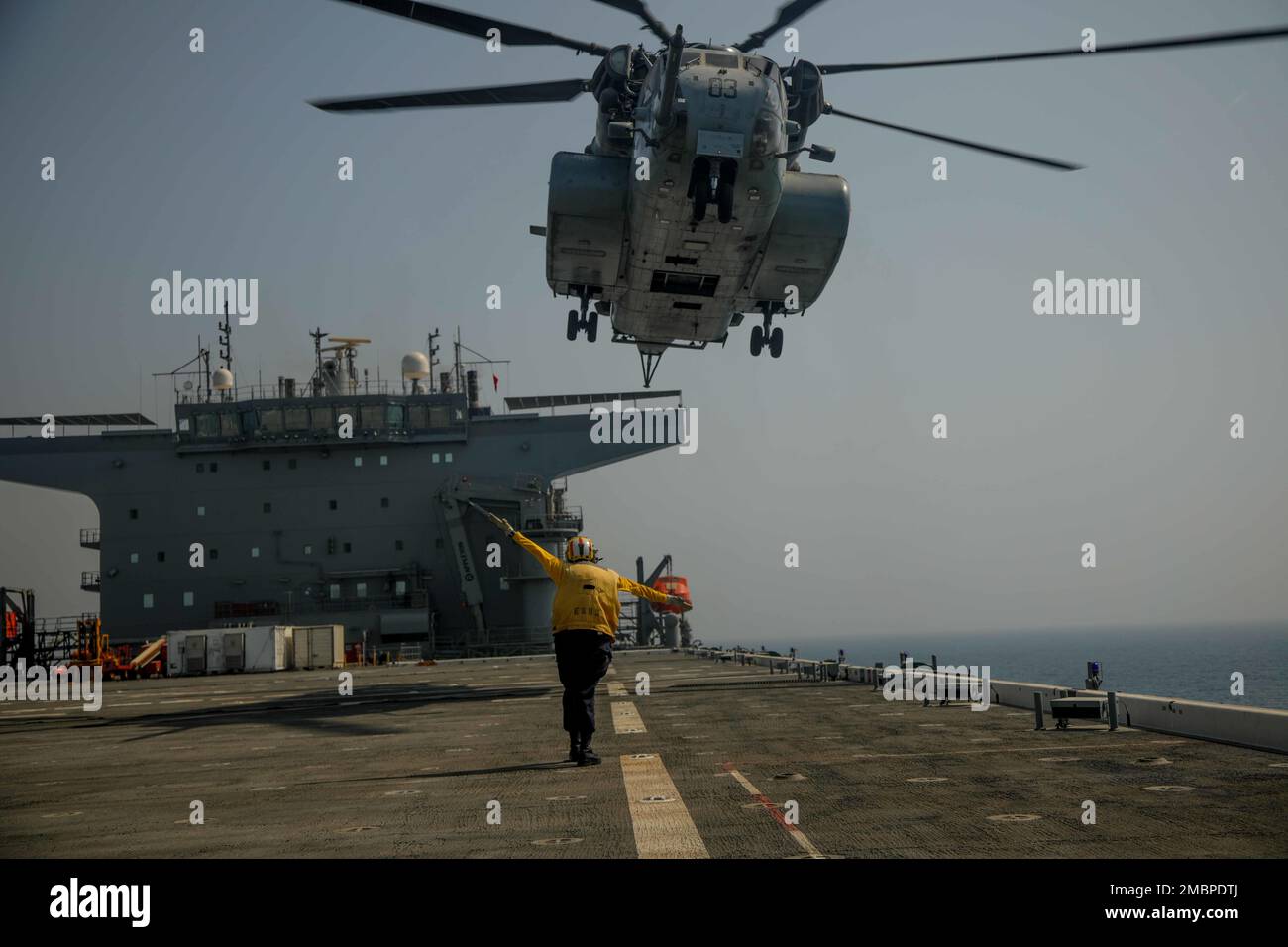220618-A-EQ028-1350 ARABIAN GULF (June 18, 2022) Aviation Boatswains Mate (Handler) 3rd Class Lauren Bryan directs an MH-53 Sea Dragon helicopter attached to the Blackhawks of Helicopter Mine Countermeasures (HM) Squadron 15, during flight operations aboard the expeditionary sea base USS Lewis B. Puller (ESB 3), during exercise Iron Defender in the Arabian Gulf, June 18. Iron Defender is an annual bilateral training event between U.S. Naval Forces Central Command and forces from the United Arab Emirates. The exercise focuses on maritime security operations, mine countermeasures, and harbor def Stock Photo