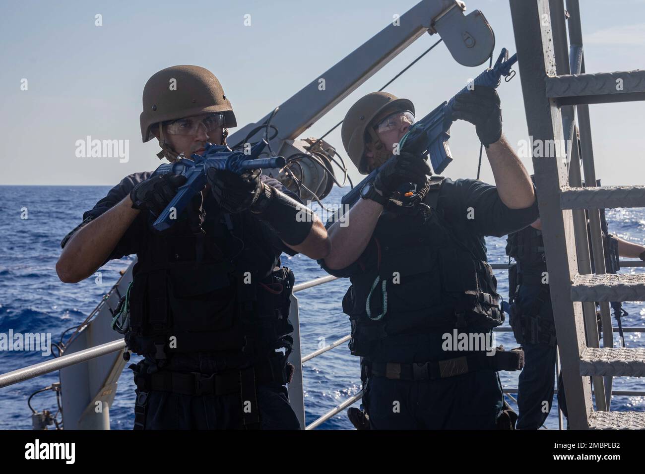 220618-N-UL352-2162 ATLANTIC OCEAN (June 18, 2022) Lt. j.g. Curtis McDonnell, left, and Information Systems Technician 1st Class Michael Steele, both assigned to the Arleigh Burke-class guided-missile destroyer USS Delbert D. Black (DDG 119), conduct tactical movements during a visit, board, search, and seizure (VBSS) training exercise aboard training support vessel USNS Narragansett (TSV 4), June 18, 2022. The George H.W. Bush Carrier Strike Group (CSG) is underway completing a certification exercise to increase U.S. and allied interoperability and warfighting capability before a future deplo Stock Photo