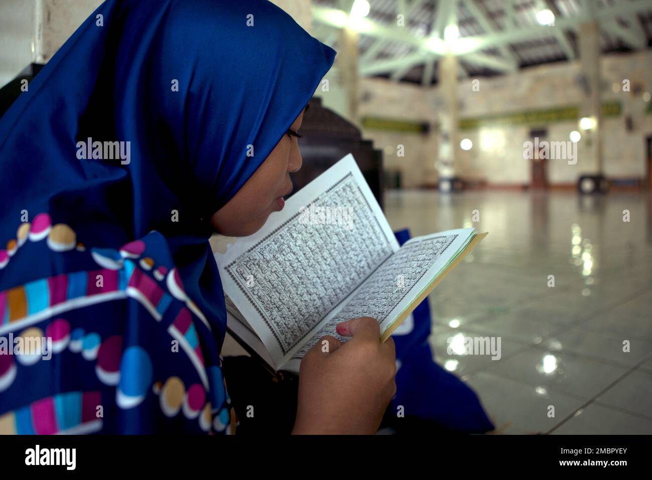 A Muslim woman reads the Quran at a mosque during the first day of the holy  fasting month of Ramadan in Denpasar, Bali, Indonesia on Sunday, April 3,  2022. (AP Photo/Firdia Lisnawati