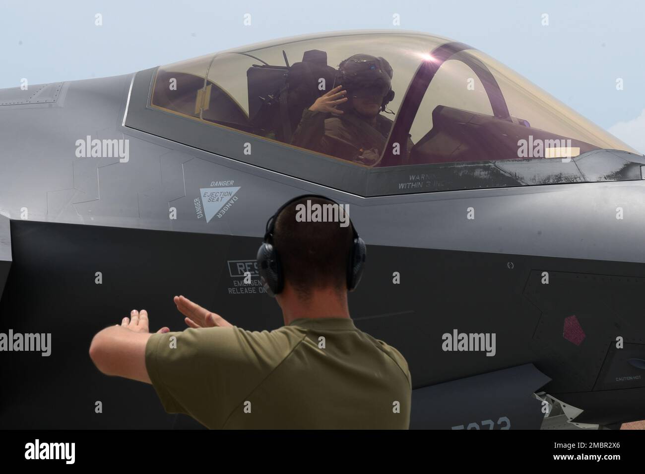 U.S. Air Force Airman 1st Class Joshua Hamrick, a 356th F-35 Expeditionary Fighter Squadron crew chief, marshals a 356th EFS F-35A Lightning II pilot, during Agile Combat Employment training at Marine Corps Air Station Iwakuni, Japan, June, 20, 2022. ACE is Pacific Air Forces’ model to project combat power via a network of distributed operating locations throughout the Indo-Pacific region. Stock Photo