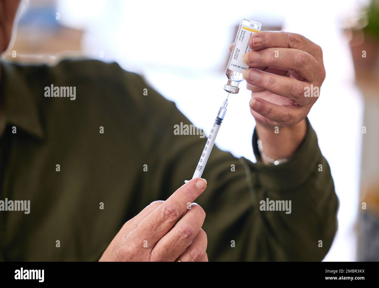 Healthcare, needle and bottle for medicine, cure and treatment for illness, vaccine and self care. Hands, injection or container with liquid, medical Stock Photo