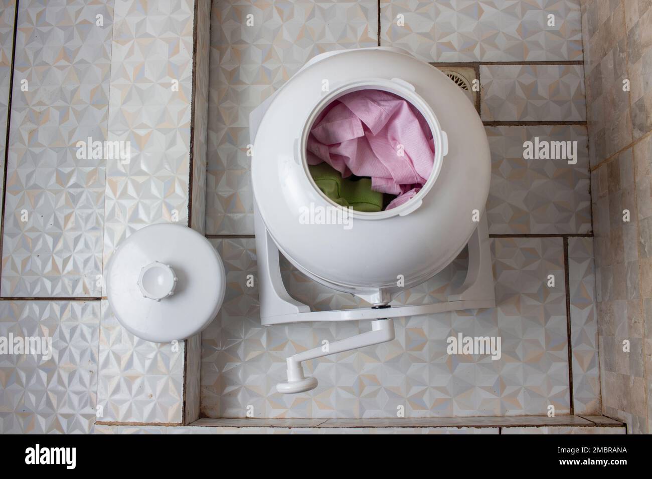 Clothes loaded into eco-friendly and convenient, non-electric portable manual washing machine Stock Photo