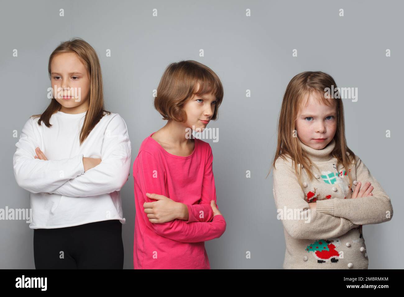 Offended displeased children friends with crossed arms. Young girls 8-10 years old portrait Stock Photo