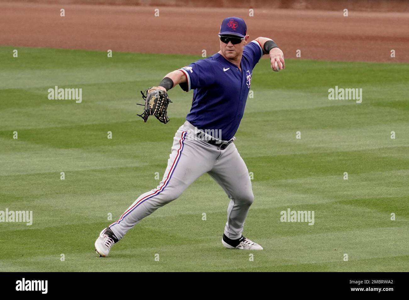 Texas Rangers right fielder Kole Calhoun throws during the second inning of  a spring training baseball game against the Seattle Mariners Monday, March  28, 2022, in Peoria, Ariz. (AP Photo/Charlie Riedel Stock