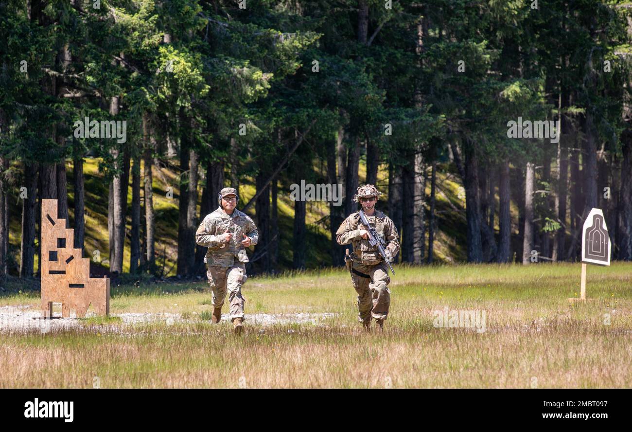 Two soldiers, a grader and a demonstrator, run through a field at a range to demonstrate the route during a 3-gun marksmanship competition for the I Corps Best Squad Competition, June 21, 2022, at Joint Base Lewis-McChord, Washington. Eleven squads competed over five competition days in events including marksmanship, fitness tests, field exercises, obstacle courses, a ruck march and a review board. Stock Photo