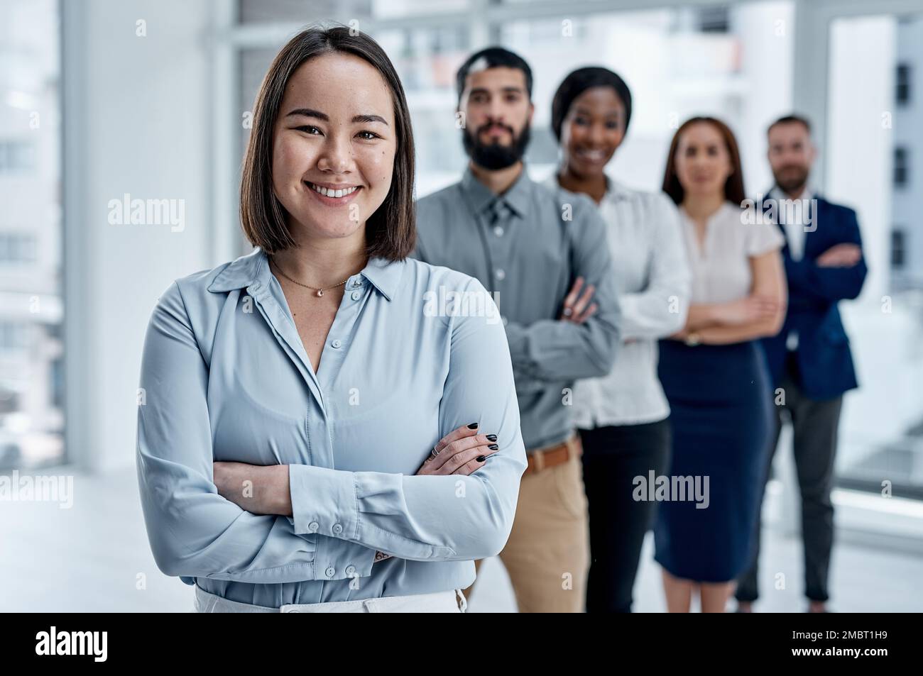 Im so thankful for an amazing team behind me. Portrait of a businesswoman standing in an office with her colleagues in the background. Stock Photo