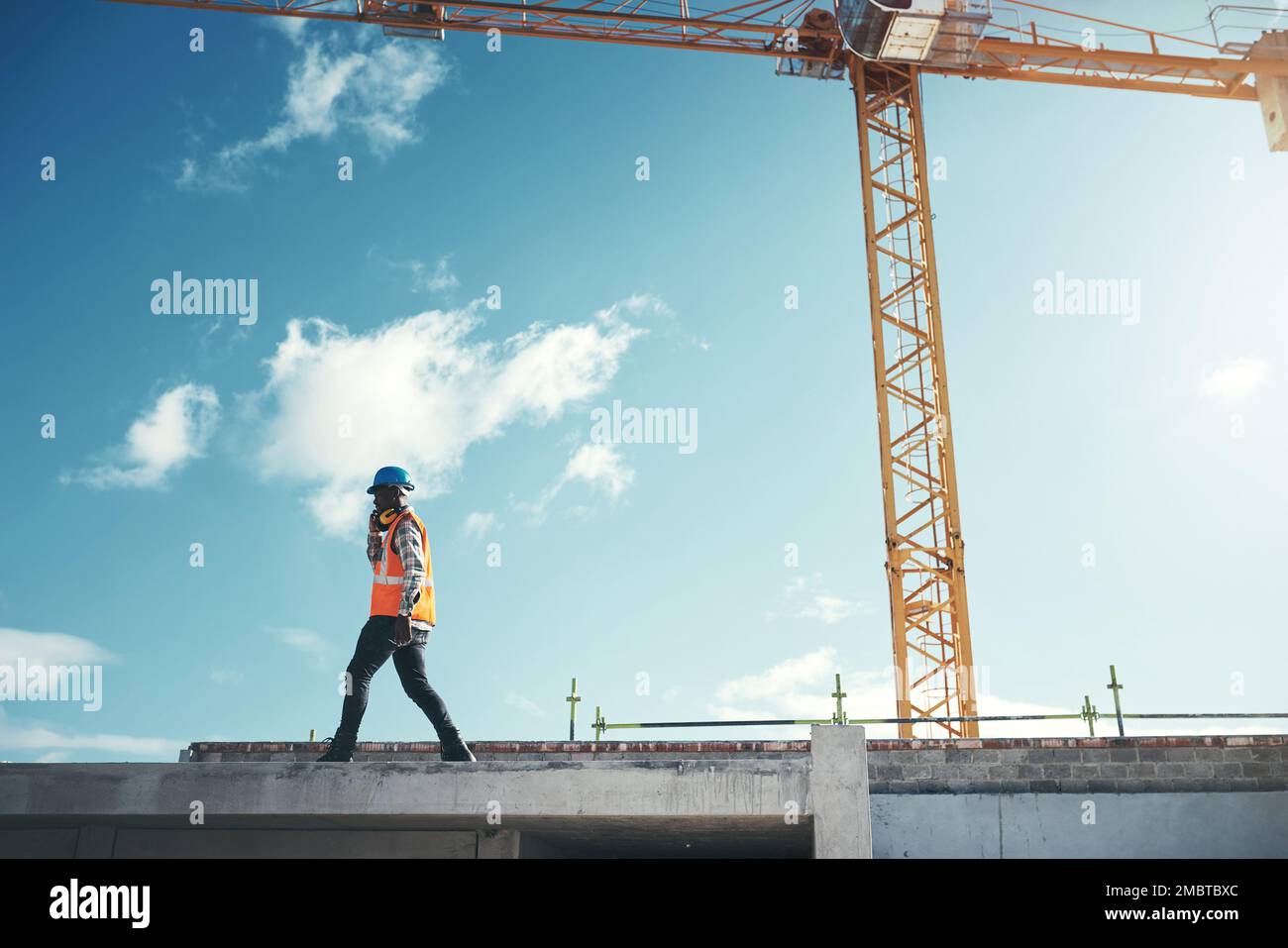 Next level quality construction. a young man using a smartphone while working at a construction site. Stock Photo