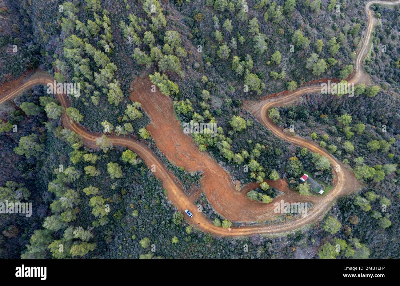 Drone aerial of rural curved road passing through the mountain. Discovery and adventure in nature. Troodos Cyprus Stock Photo