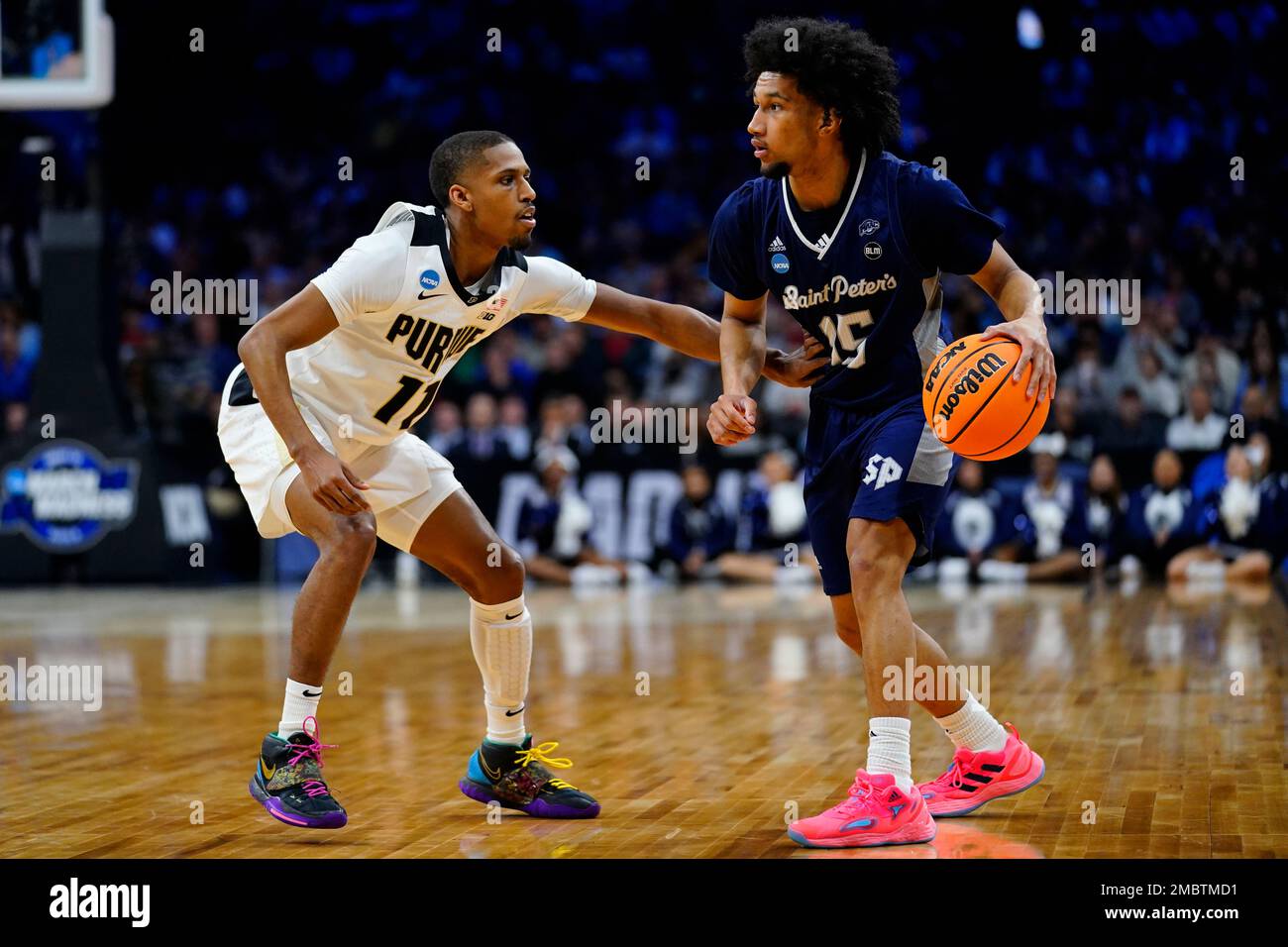 Saint Peter's Matthew Lee, right, dribbles against Purdue's Isaiah Thompson  during the first half of a college basketball game in the Sweet 16 round of  the NCAA tournament, Friday, March 25, 2022,