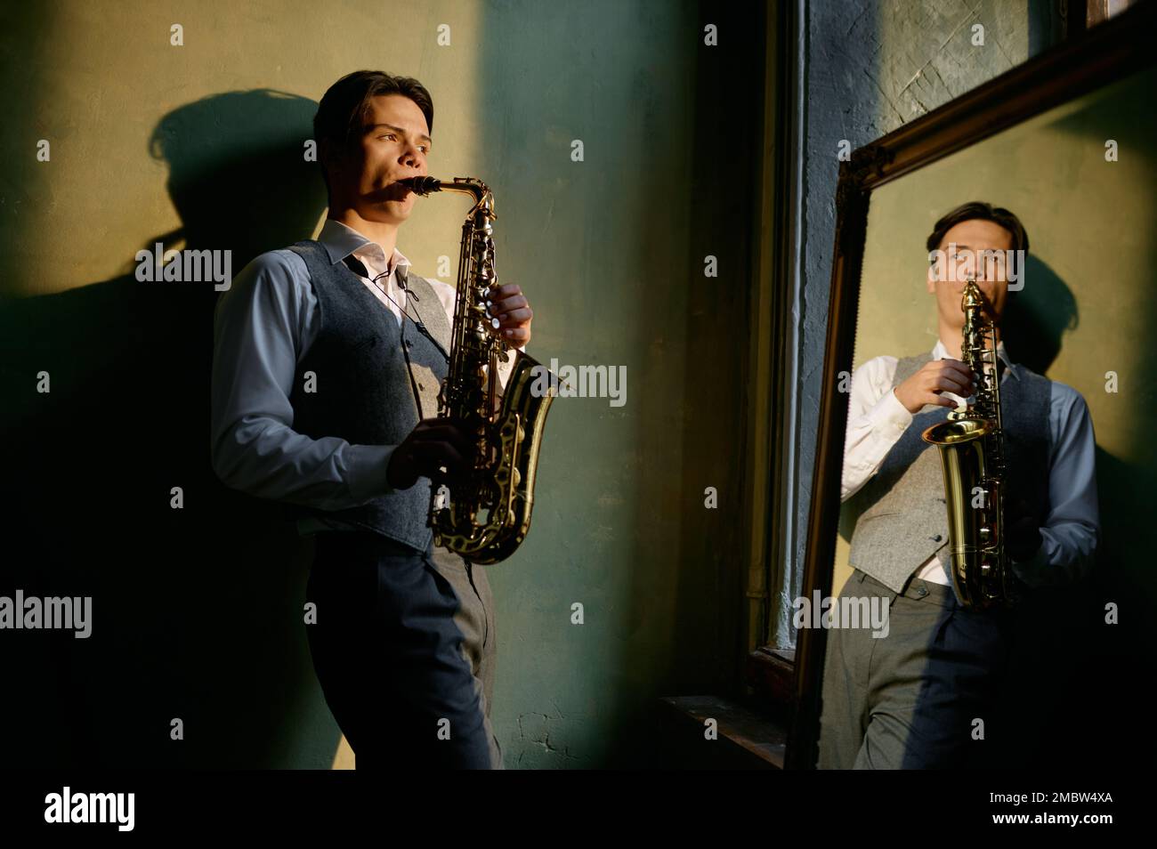 Young male saxophonist playing musical wind instrument Stock Photo