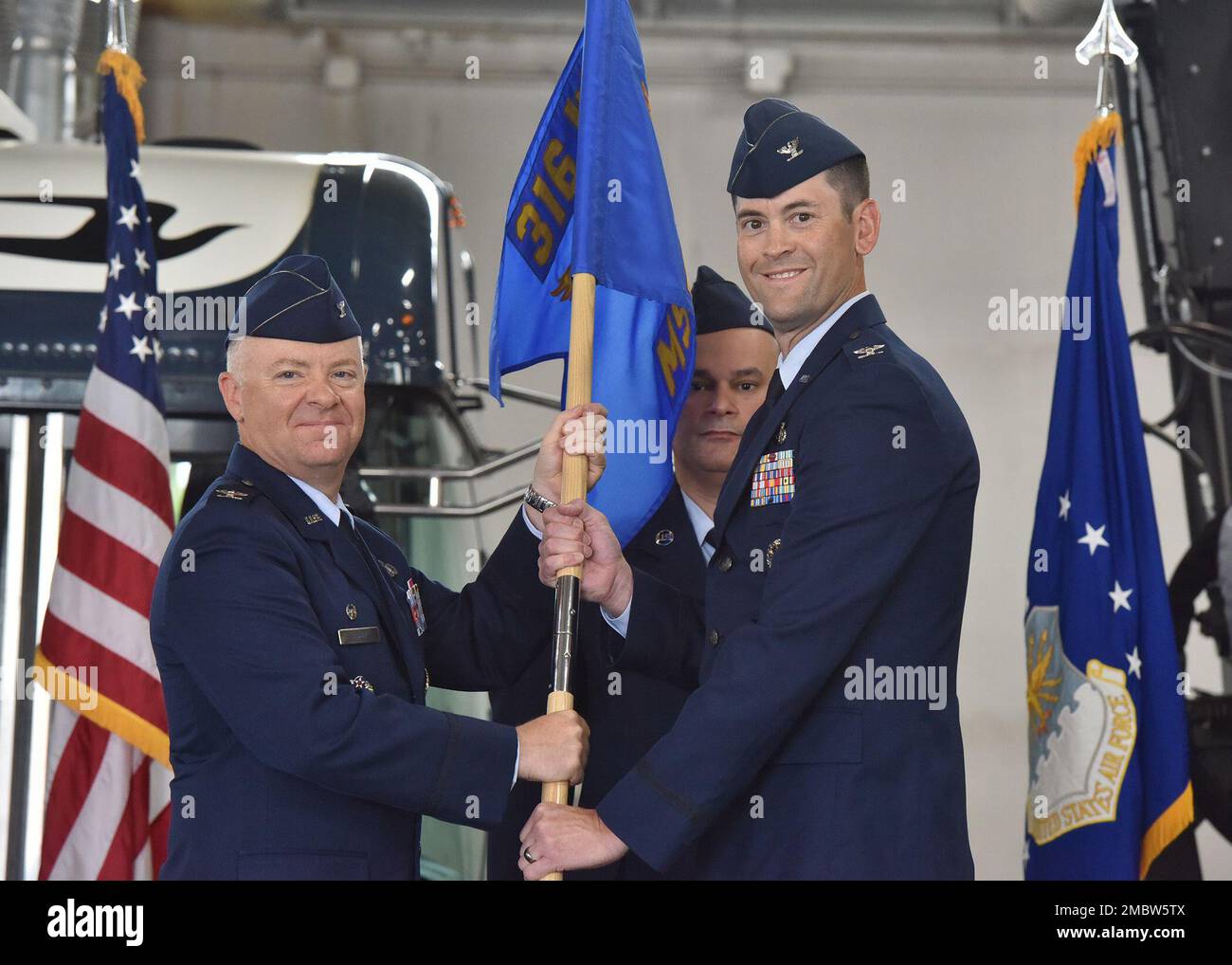 Col. Nate Somers, right, accepts command of the 316th Mission Support Group from Col. Tyler Schaff, 316th Wing and Joint Base Andrews installation commander, during a change of command ceremony at Joint Base Andrews, Md., June 22, 2022. Chief Master Sgt. Anibal Rodriguez, 316th MSG senior enlisted leader, looks on. Stock Photo