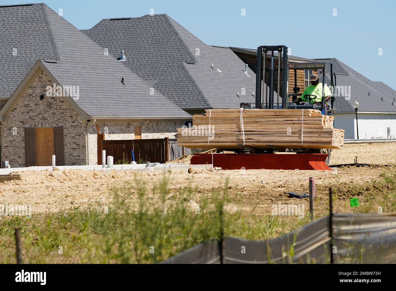A load of framing material is placed at a site at a new housing ...