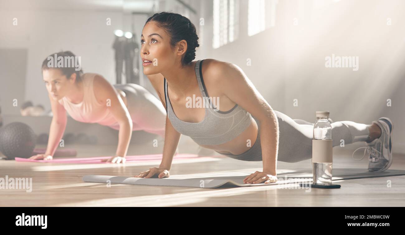 If its not hard, youre not doing it right. two young athletes working out together at the gym. Stock Photo