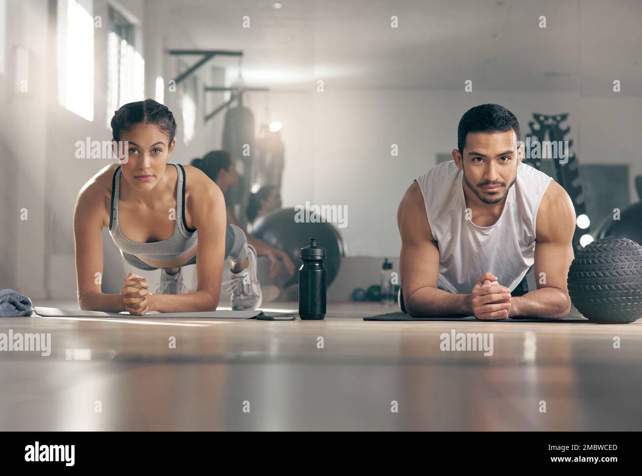 The harder it gets, the stronger you become. two young athletes working out together at the gym. Stock Photo