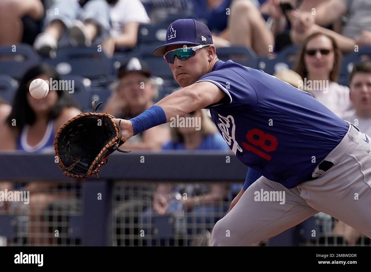 Los Angeles Dodgers' Jake Lamb catches a ball during the first inning of a  spring training baseball game against the Seattle Mariners Saturday, March  19, 2022, in Peoria, Ariz. (AP Photo/Charlie Riedel