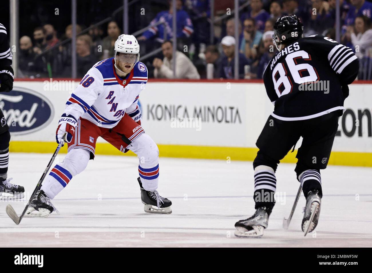 New York Rangers center Andrew Copp 18 defends as New Jersey Devils center Jack Hughes skates during the second period of an NHL hockey game Tuesday March 22 2022 in Newark N.J