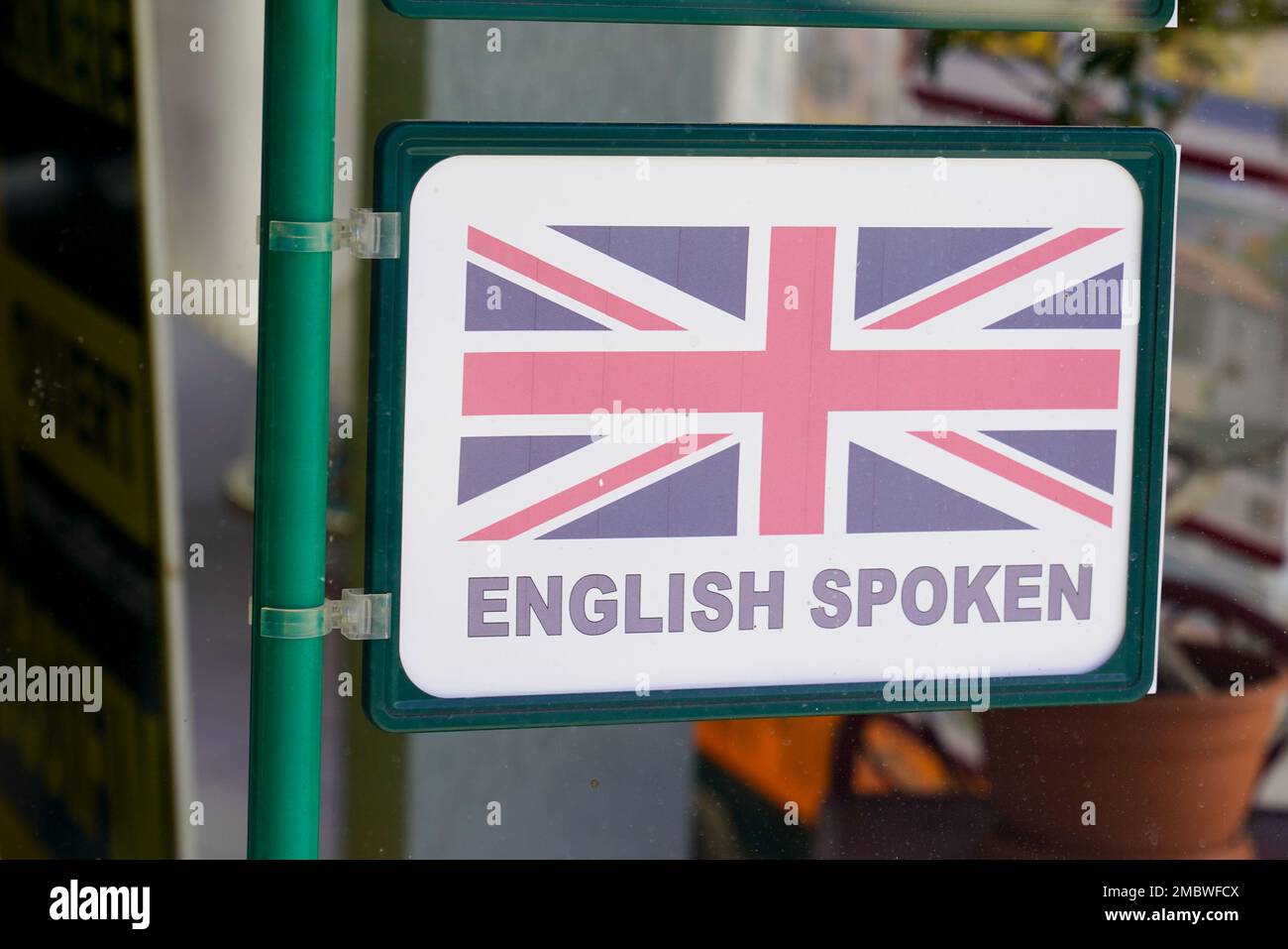 Sticker with text english spoken on windows store entrance for tourist customer during vacation holidays Stock Photo
