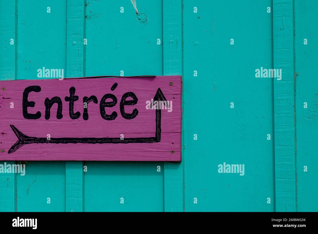 pink sign indicating entree in french text means entry with black arrow