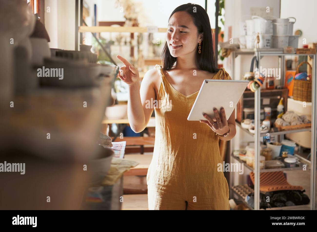 Art studio stock check, woman and tablet data of a entrepreneur checking store information. Happy, smile and startup professional busy working on a Stock Photo
