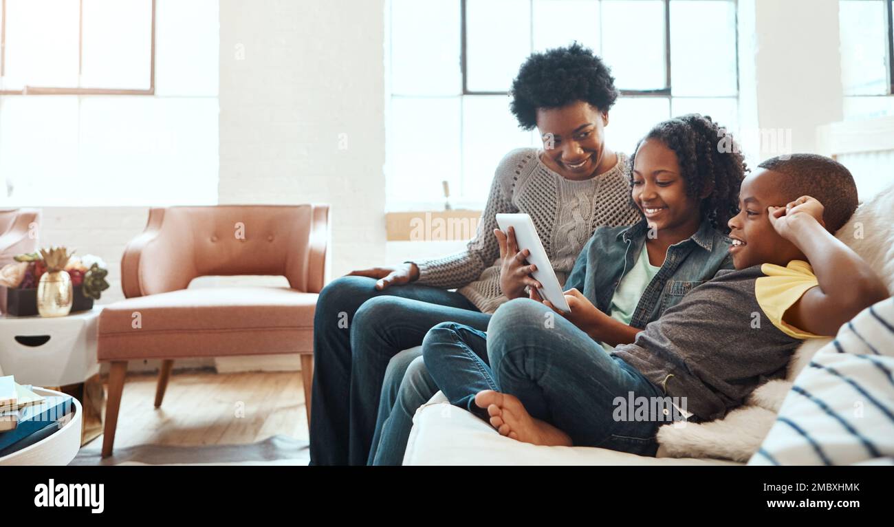 Family with tablet, streaming and relax at family home together, spending quality time together with technology. Black people, mother and children on Stock Photo