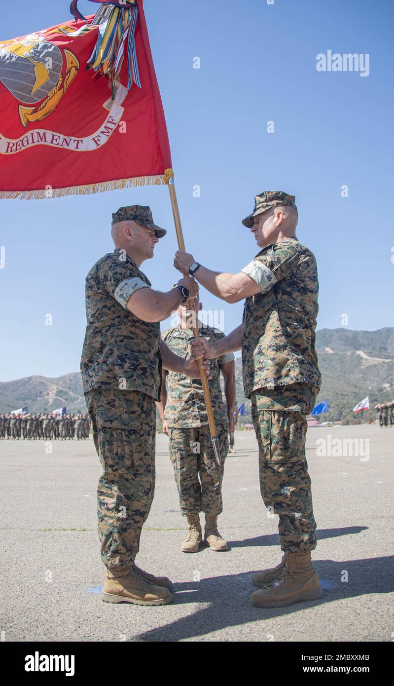 U.S. Marine Corps Col. Brandon Graham (right), the outgoing commanding officer of 1st Marine Regiment, 1st Marine Division (1st MARDIV), transfers the unit colors to Col. Brendan Sullivan (left), the incoming commanding officer of 1st Marine Regiment, 1st MARDIV, during a change of command ceremony at Marine Corps Base Camp Pendleton, California, June 23, 2022. During the ceremony, Graham relinquished command of 1st Marine Regiment to Sullivan. Stock Photo