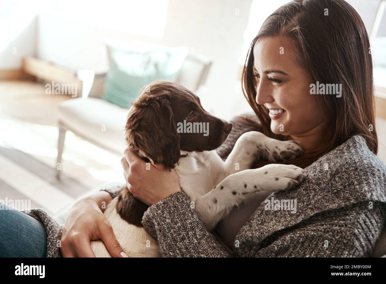 Pet, smile and dog mom in a home on a living room couch with dog bonding with care. Animal love, puppy and person with happiness at home with a smile Stock Photo