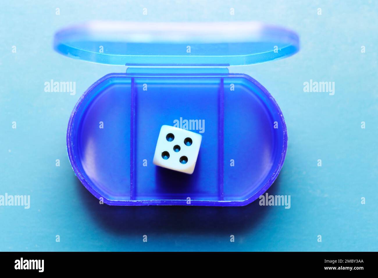 blue plastic box with compartments, a die into one Stock Photo