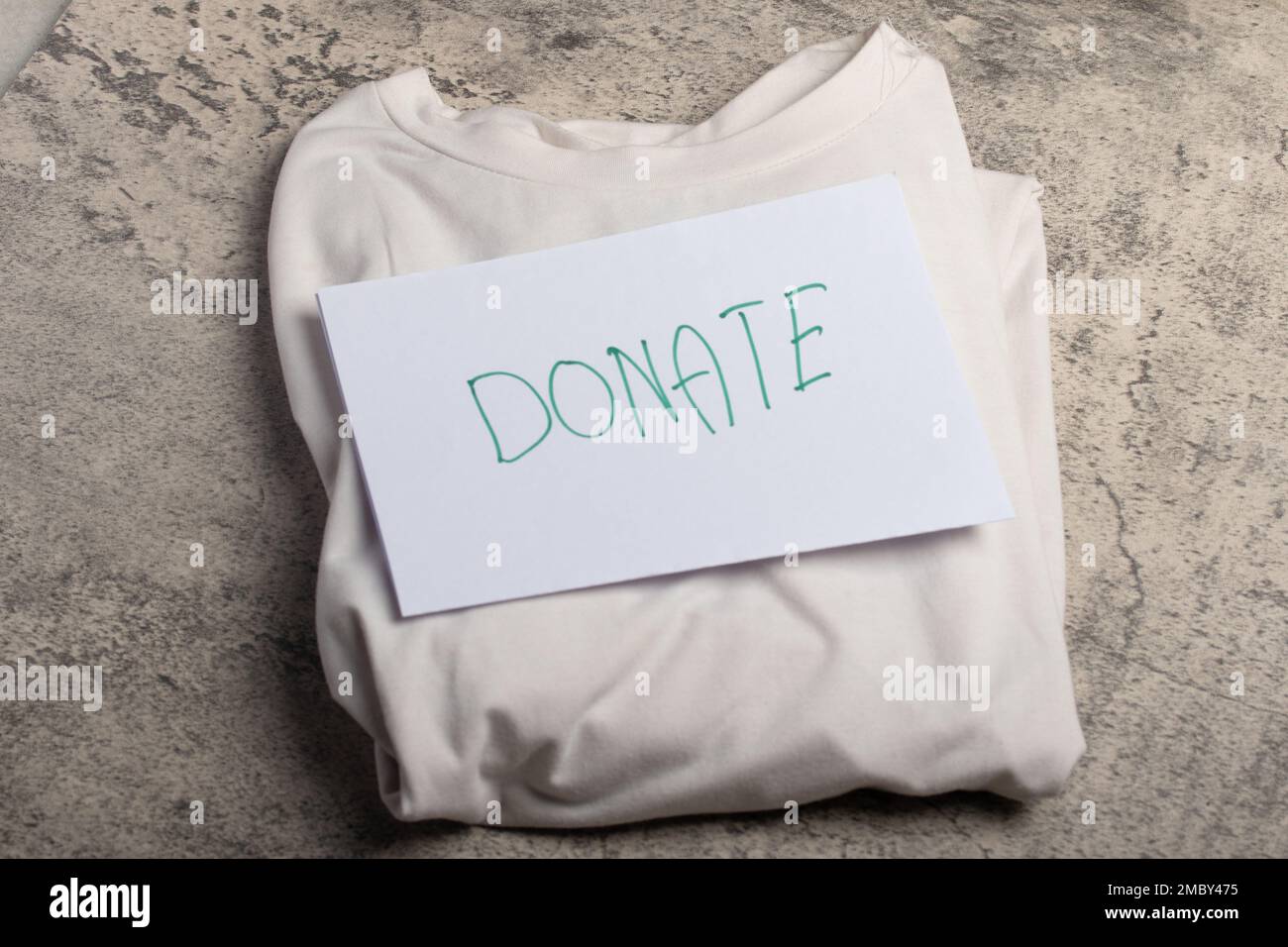 White shirt laying on the floor accepting clothing donations, top view