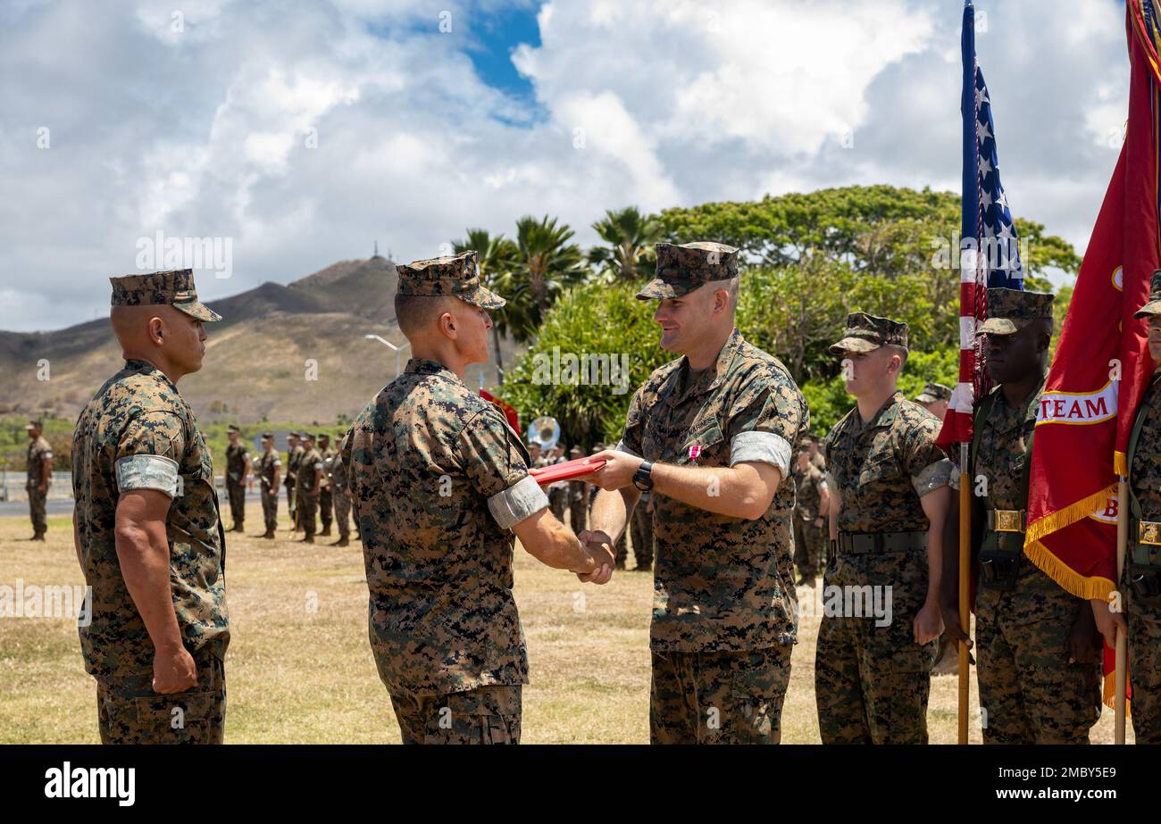 U.S. Marine Corps Col. Timothy S. Brady Jr, commanding officer, 3d Marine Littoral Regiment, presents Lt. Col. Adam R. Sacchetti, offgoing commanding officer of 3d Littoral Combat Team, an award during a change of command ceremony at Marine Corps Base Hawaii, June 23, 2022. The ceremony is a tradition symbolizing the transfer of authority, responsibility and accountability of the Marines and Sailors. Stock Photo