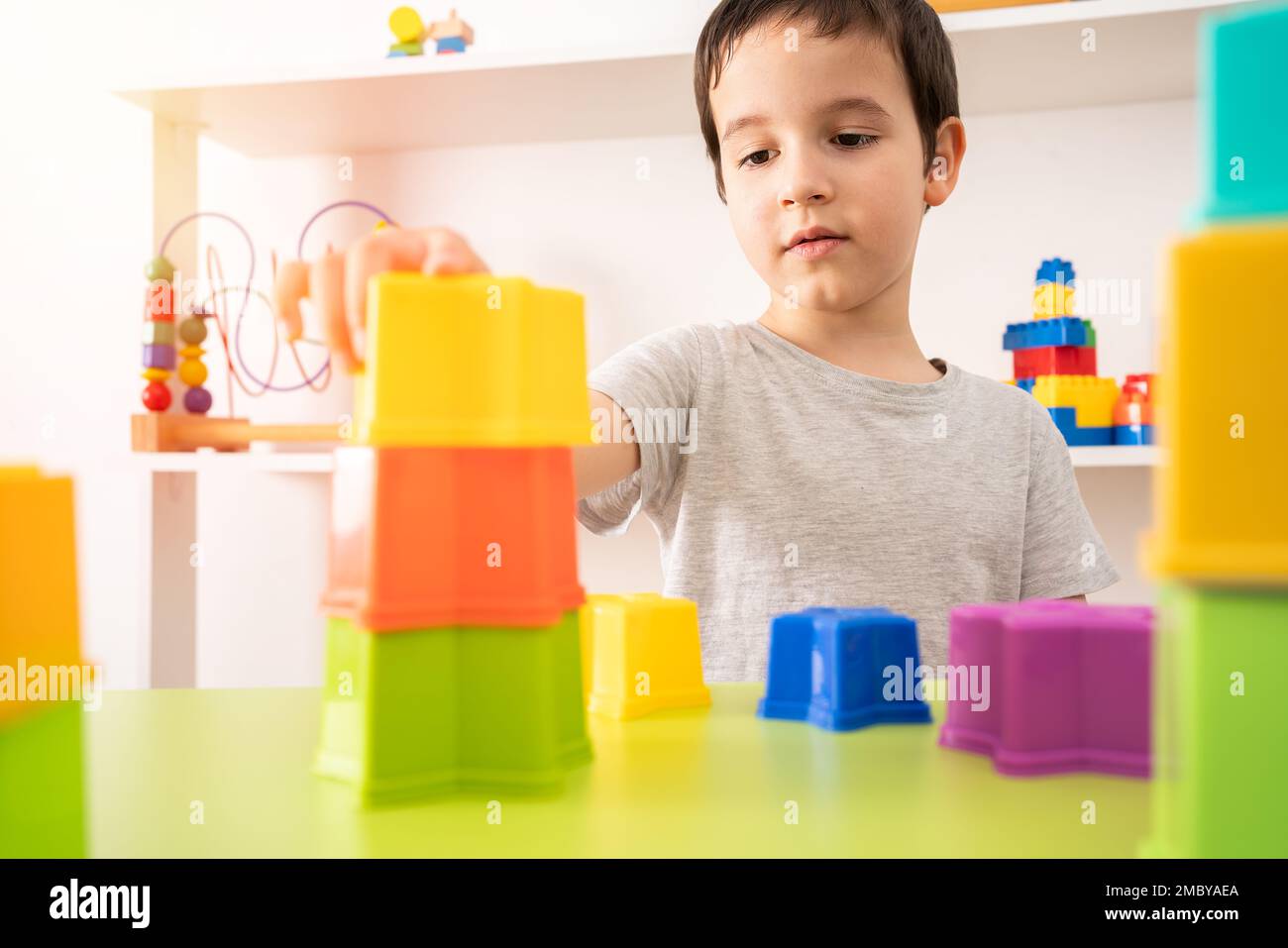 An interested pre-school child building something with plastic blocks. Stock Photo