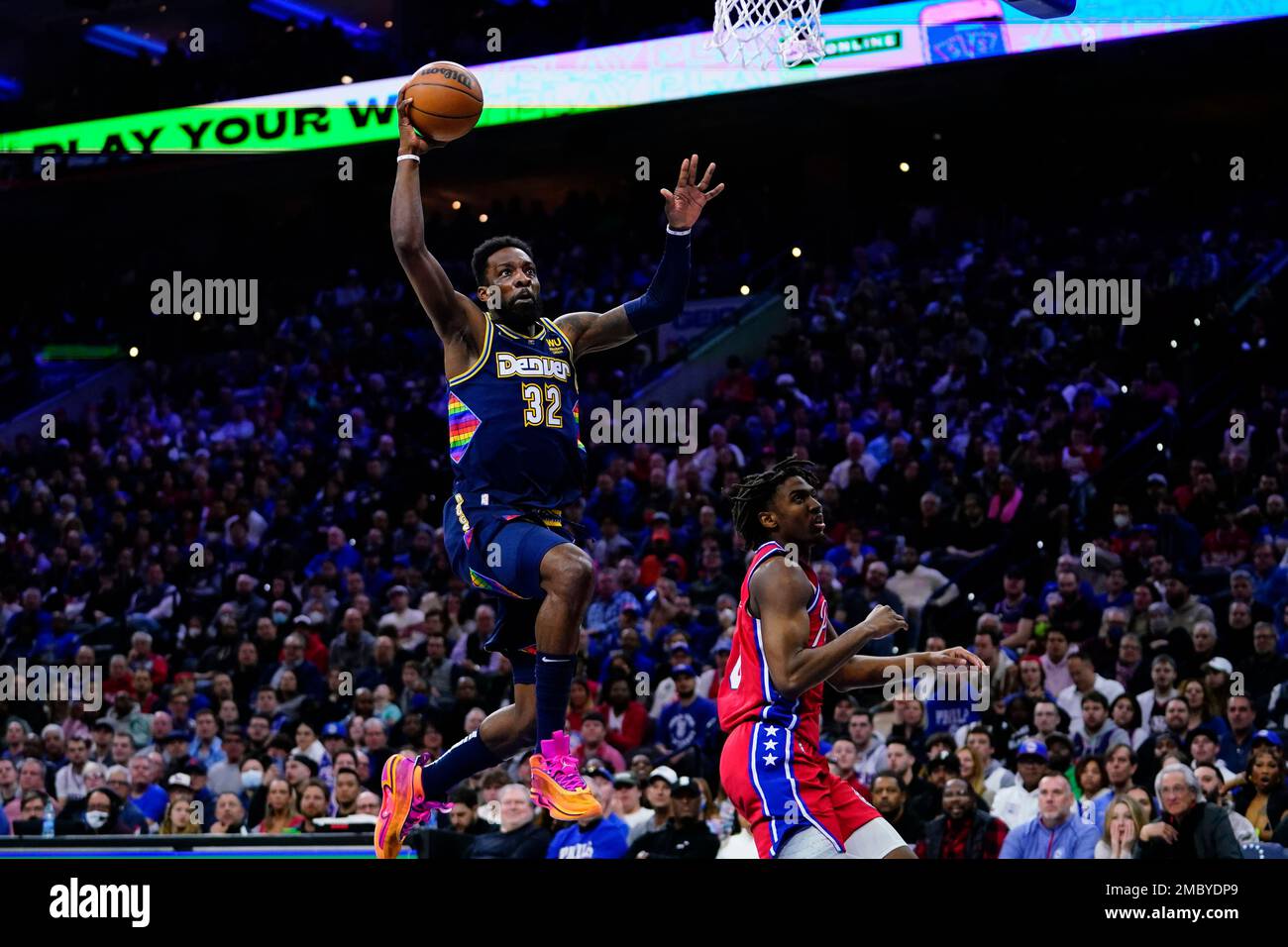 Denver Nuggets Jeff Green, left, goes up for a dunk past Philadelphia 76ers Tyrese Maxey during the first half of an NBA basketball game, Monday, March 14, 2022, in Philadelphia