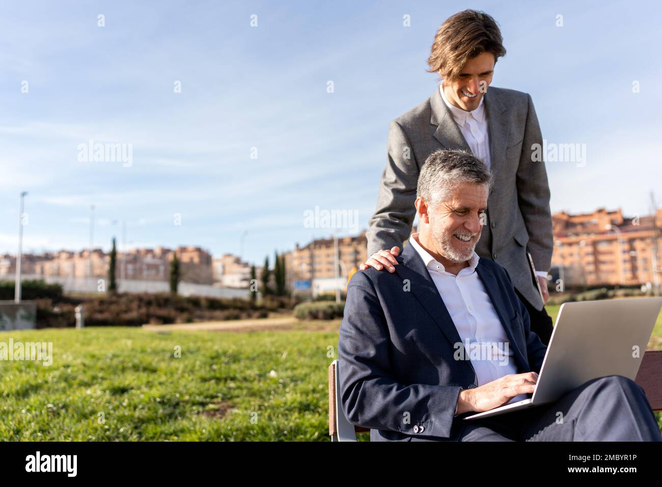 Positive businessmen in formal clothes smiling and working on remote ...
