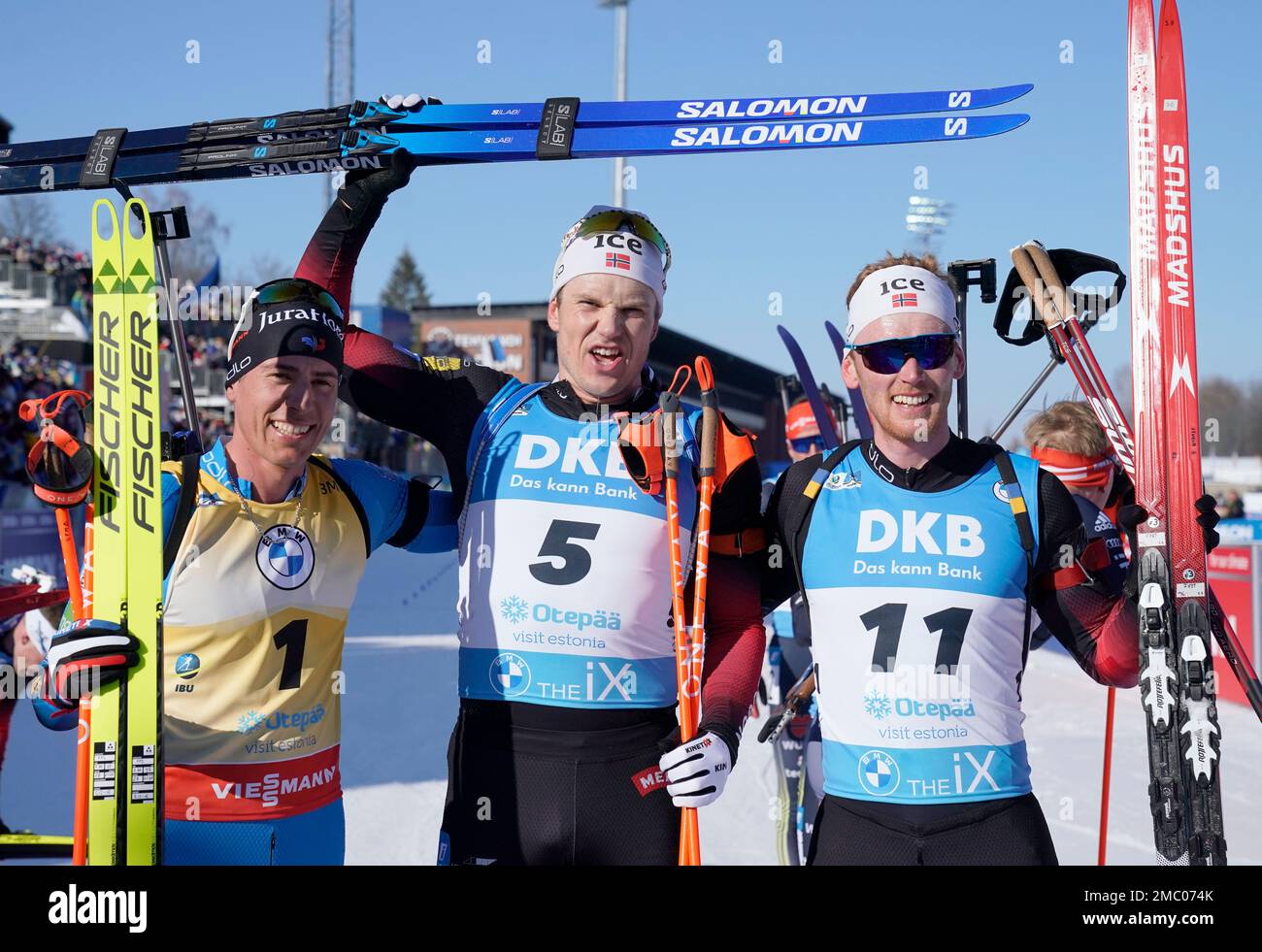 Winner Vetle Sjaastad Christiansen of Norway, center, second placed Quentin  Fillon Maillet of France, left, and third placed Sivert Guttorm Bakken of  Norway, celebrate at the finish after the men's 15km mass