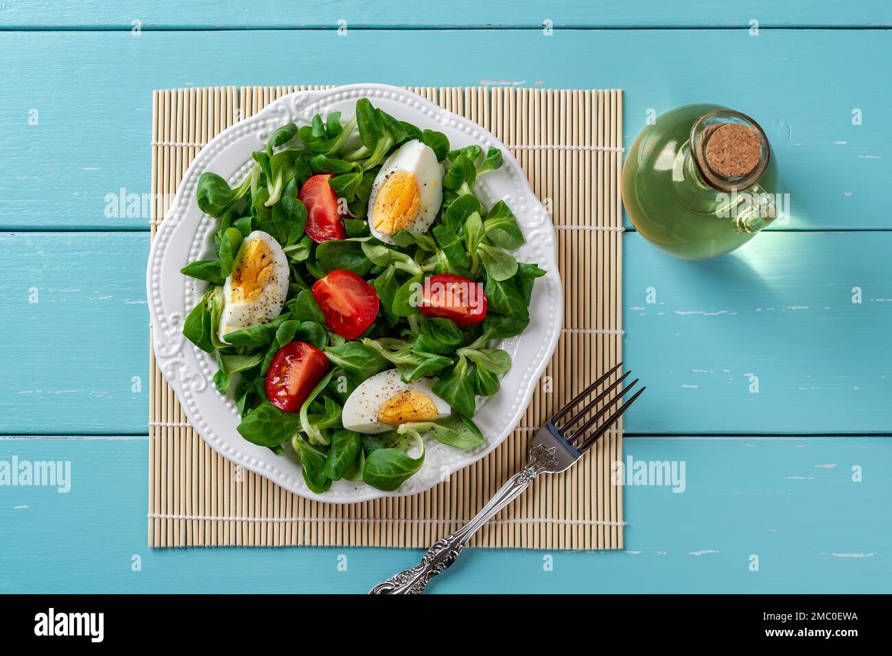 Lambs lettuce salad with tomato and boiled egg. Quartered tomato and